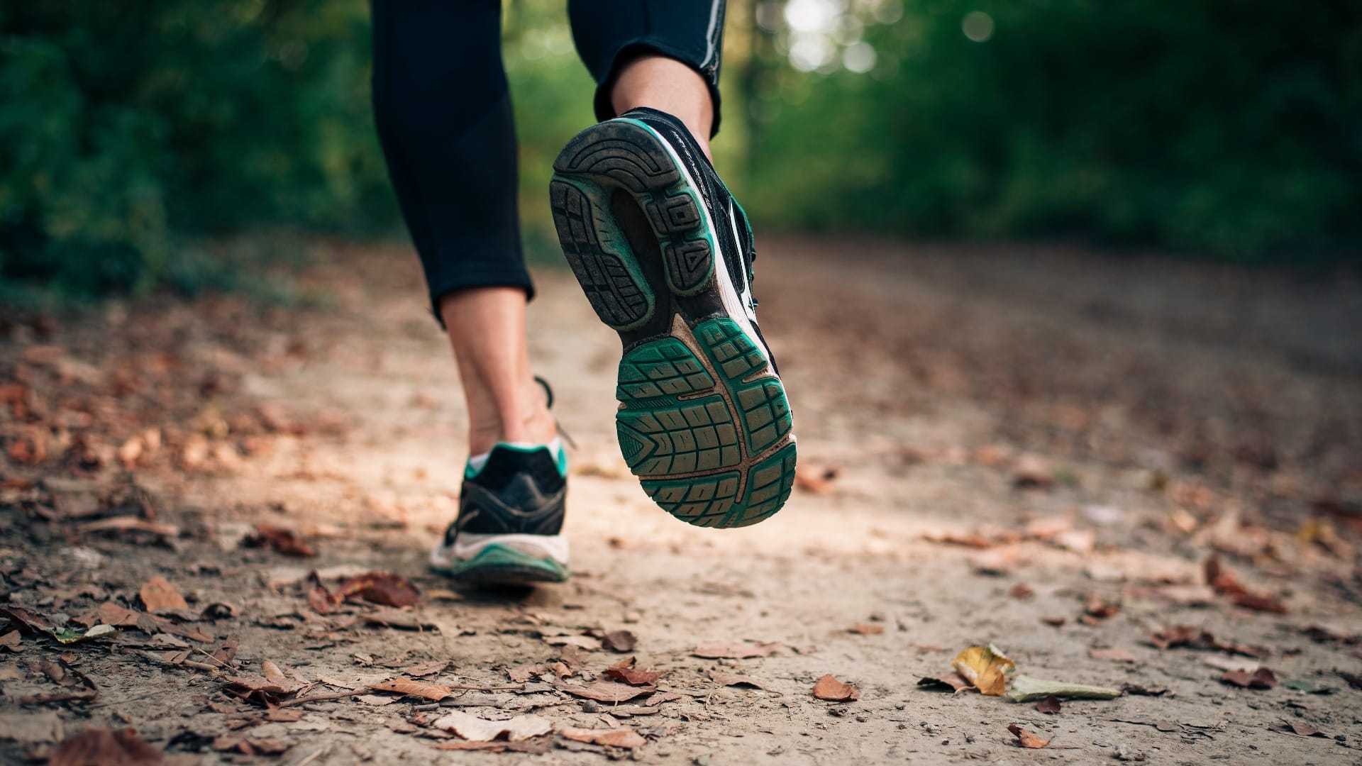 Autumn run in the nature on a trail with dry yellow leaves.