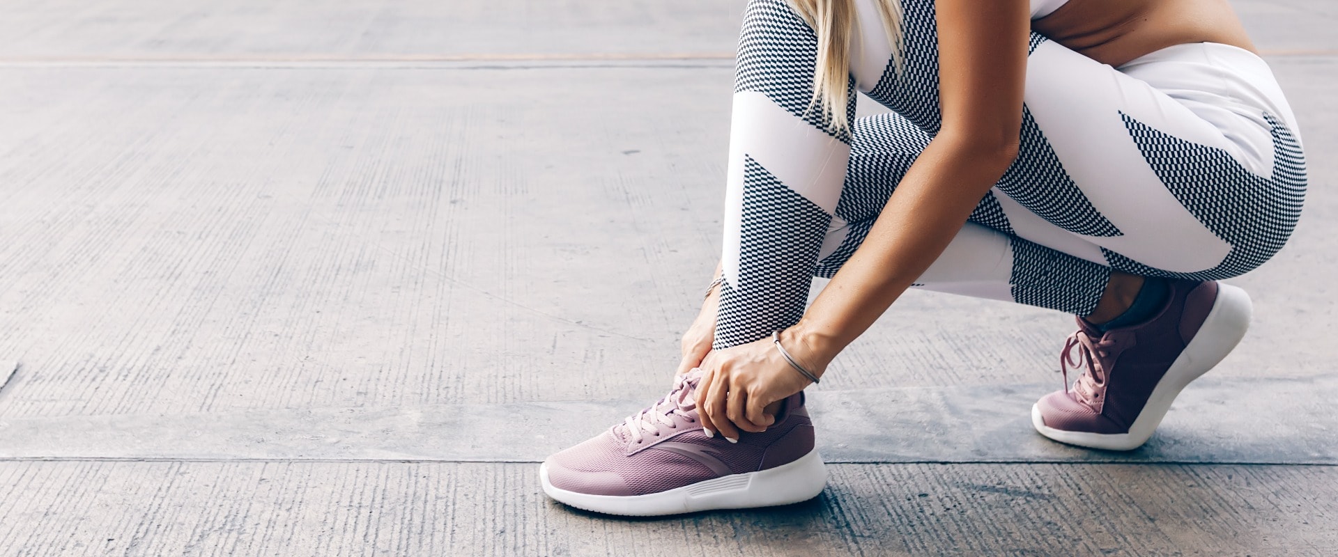 Fitness sport woman in fashion sportswear doing workout over gray wall