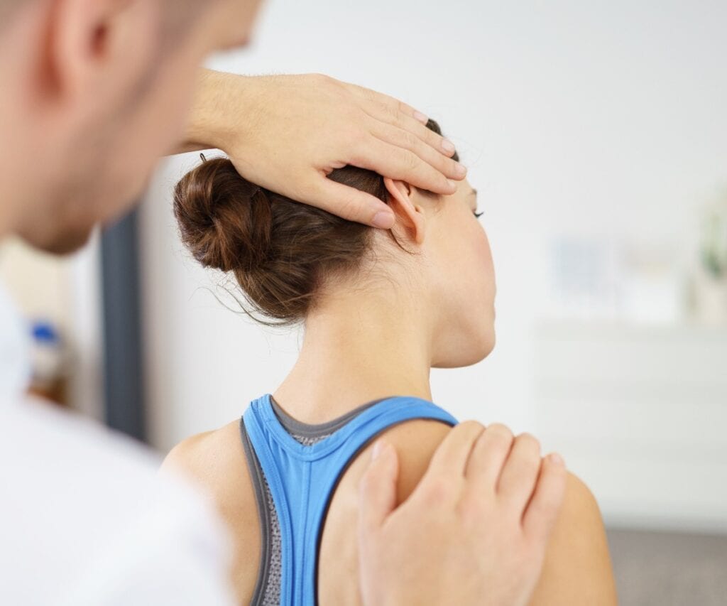 physiotherapeut behandelt eine patientin mit nackenschmerzen